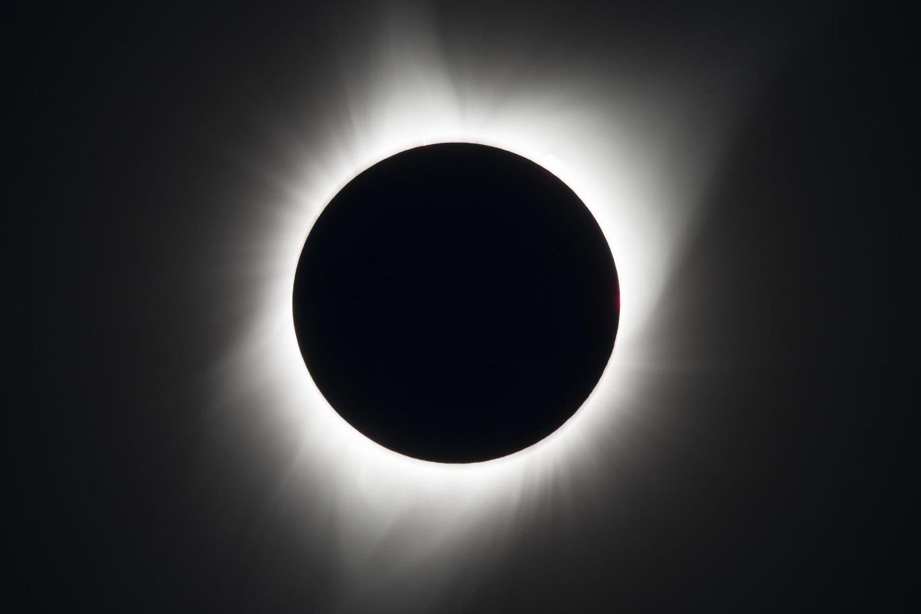 Black disc of the Moon surrounded by the Sun’s glowing white corona during a total solar eclipse