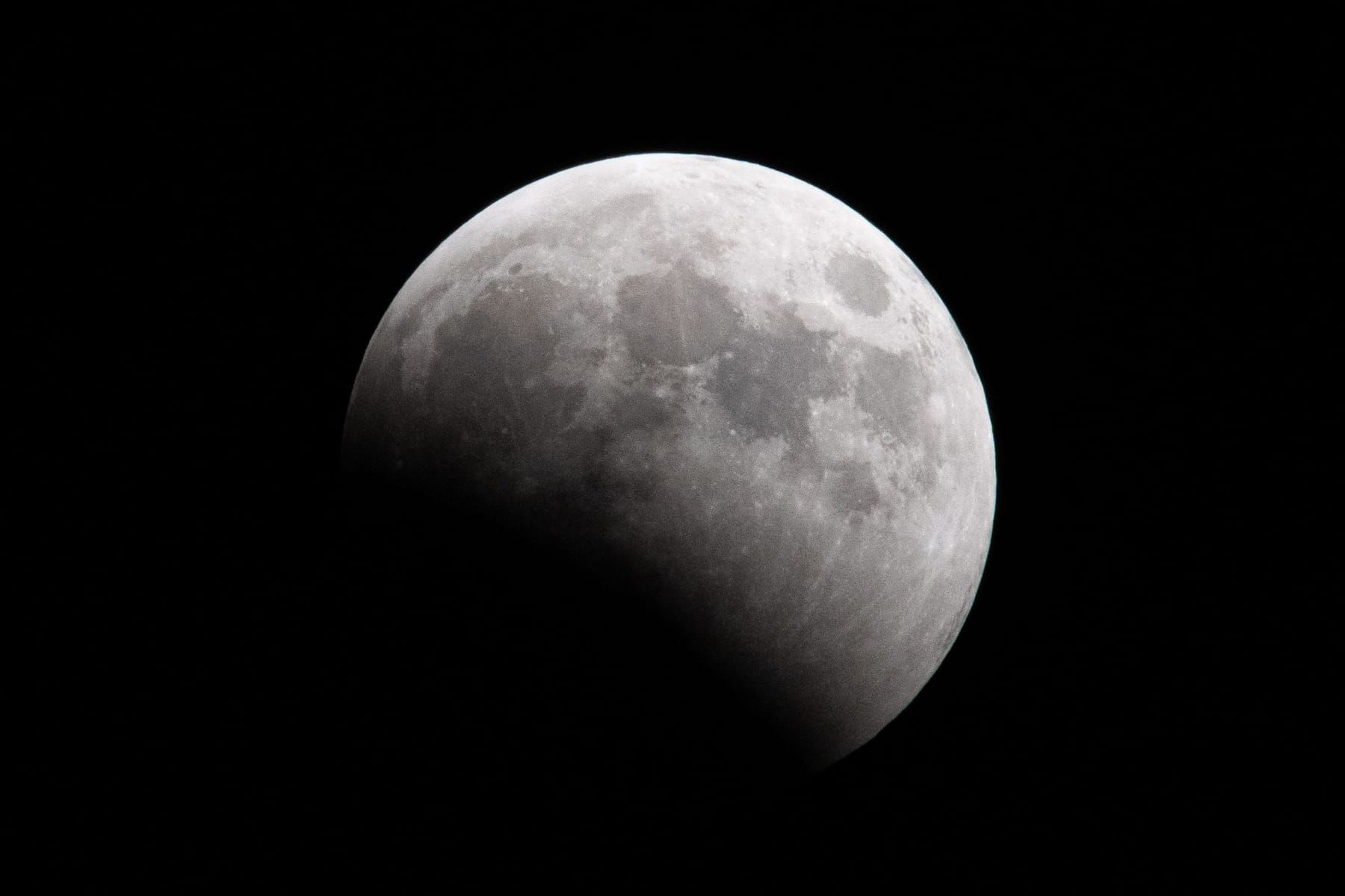 The Moon partly covered by the curved edge of Earth’s shadow
