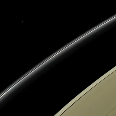 This view from NASA's Cassini spacecraft features a blue planet, Uranus, imaged by Cassini for the first time. Uranus is a pale blue in this natural color image because its visible atmosphere contains methane gas and few aerosols or clouds.